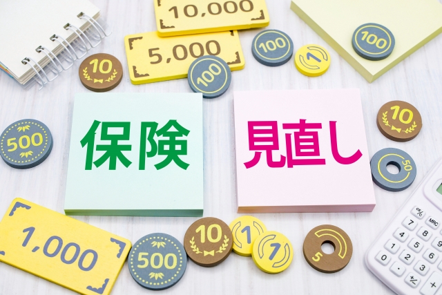 保険見直しの文字とお金、計算機、メモ帳が置いてあるイメージイラスト