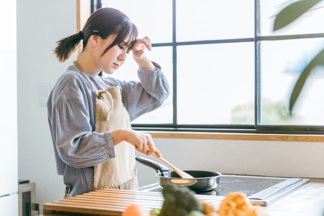 料理をしてる女性 疲れてる